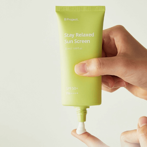 B PROJECT Stay Relaxed Sun Screen SPF50+ 50ml, sunscreen in a green tube, promoting UV protection and anti-aging benefits.